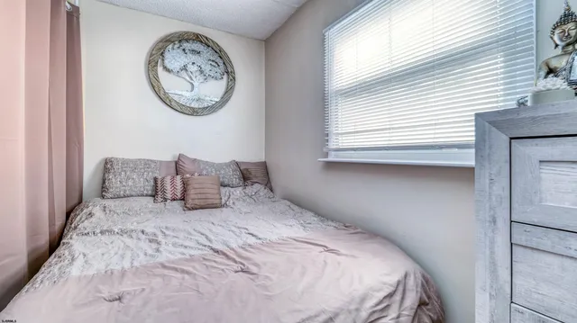 a living room with furniture a flat screen tv and a refrigerator