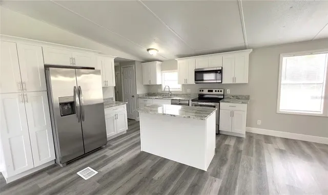 a kitchen with stainless steel appliances a refrigerator sink and microwave