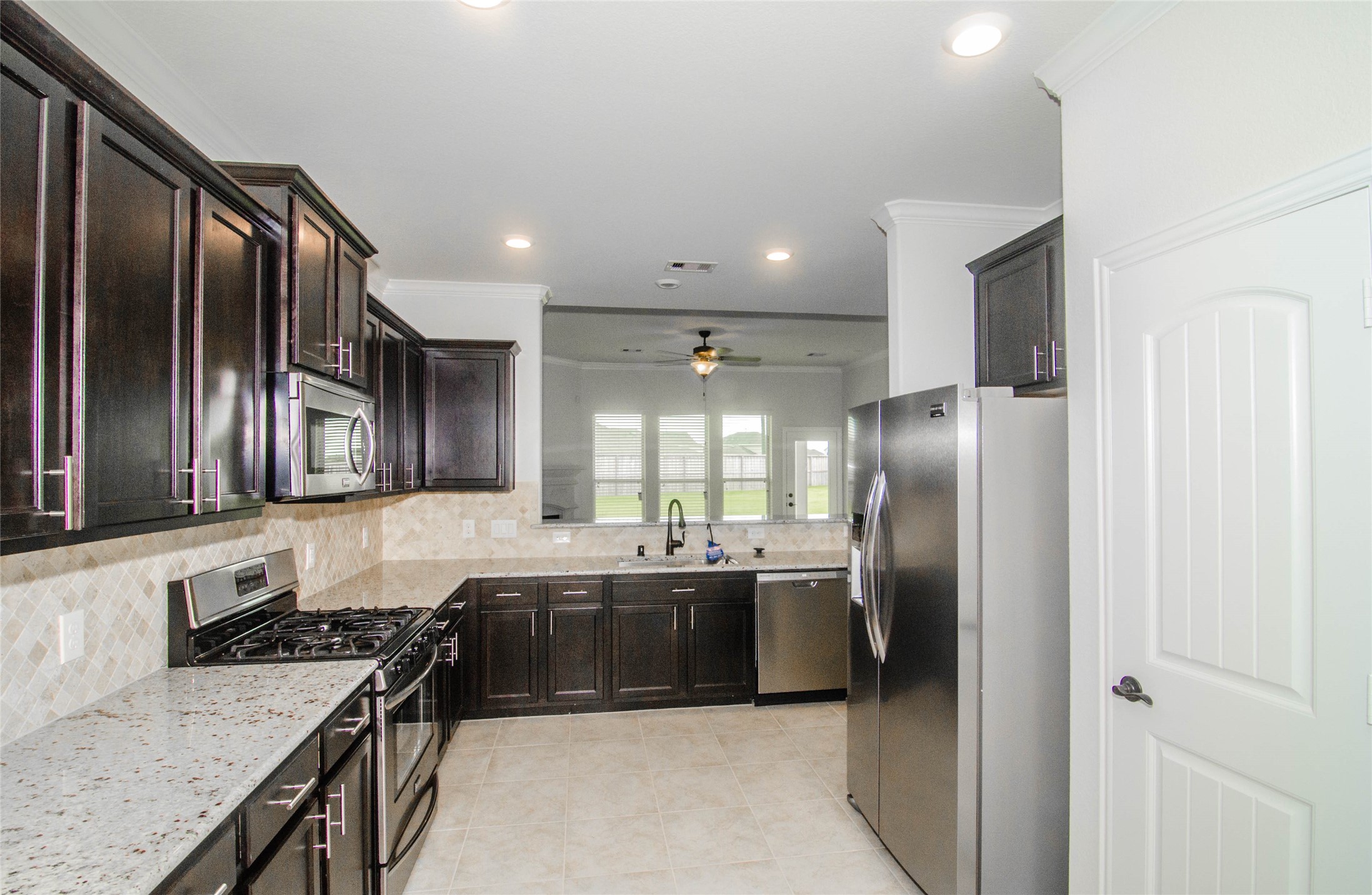 18403 Weeping Spring Drive Cypress, TX 77429 - Photo 9 of 25 a kitchen with stainless steel appliances granite countertop a sink stove and refrigerator