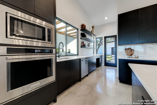 417 Southwick Ranch Johnson City, TX 78636 - Photo 12 of 45 a kitchen with stainless steel appliances kitchen island granite countertop a stove and a microwave