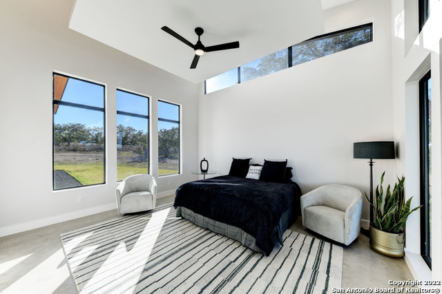 417 Southwick Ranch Johnson City, TX 78636 - Photo 15 of 45 a bedroom with a bed large window and a couch