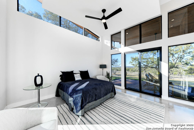 417 Southwick Ranch Johnson City, TX 78636 - Photo 16 of 45 a bedroom with a large bed and a large window