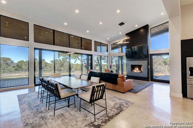 417 Southwick Ranch Johnson City, TX 78636 - Photo 5 of 45 a dining room with furniture a fireplace and wooden floor