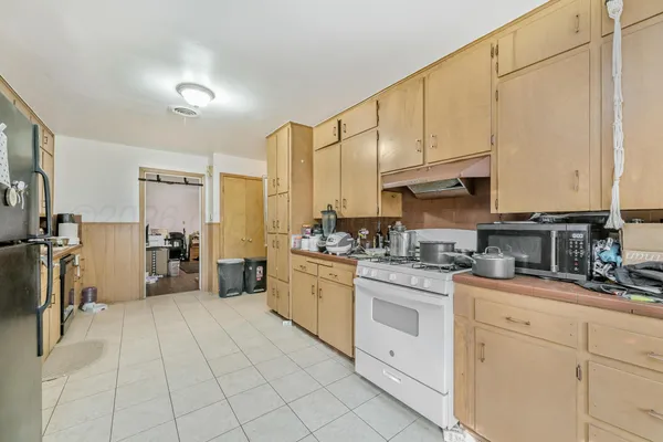 a kitchen with white cabinets and appliances