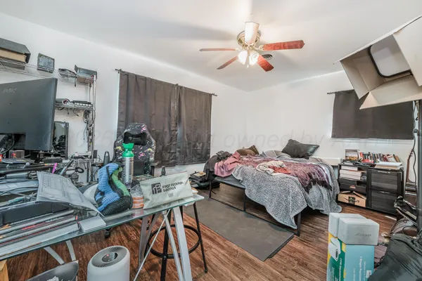 a bedroom with a bed a chandelier and a flat screen tv