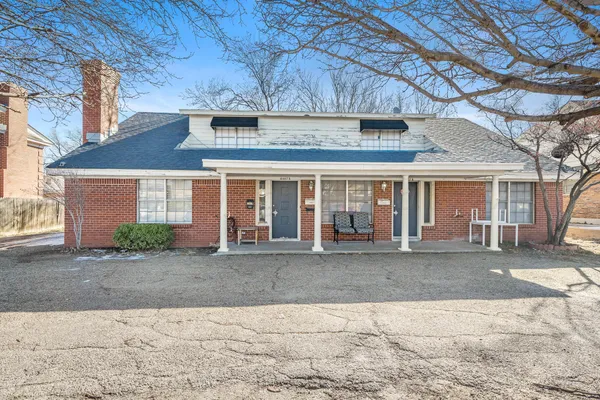 a front view of a house with a yard and outdoor seating