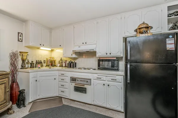 a kitchen with granite countertop white cabinets and stainless steel appliances