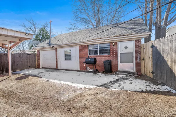 a backyard of a house with potted plants and large tree