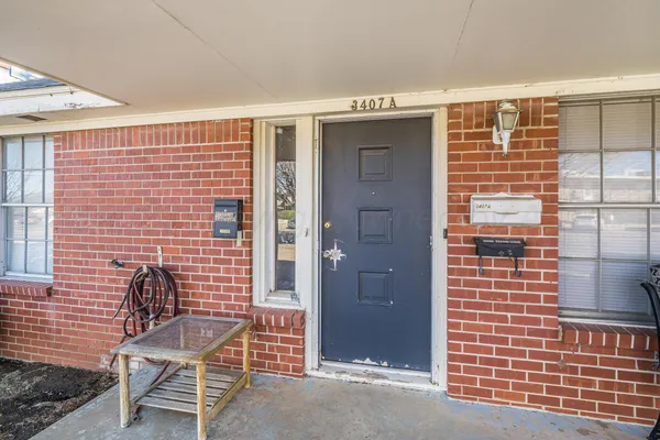 a view of a brick wall with a chair and table in the room