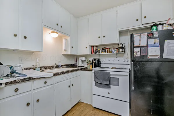 a kitchen with granite countertop white cabinets and white appliances