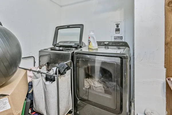 a utility room with dryer washer and view of living room
