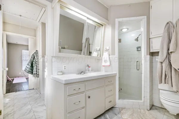 a bathroom with a double vanity sink toilet mirror and shower