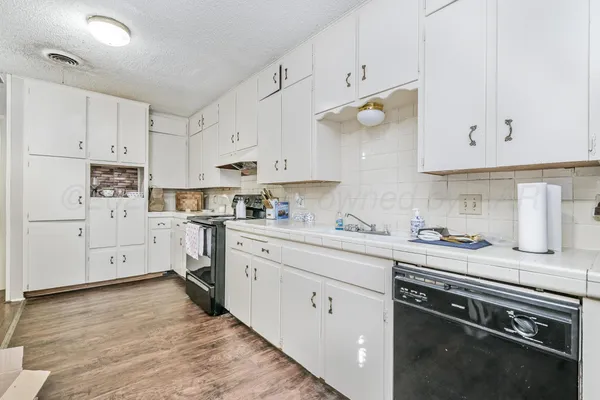 a kitchen with cabinets appliances and a window