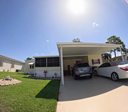 a front view of a house with a garden and parking space