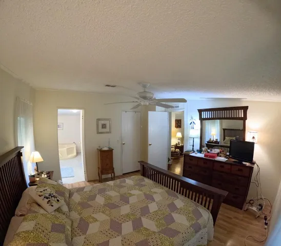 a bedroom with a bed and a bathroom with mirror