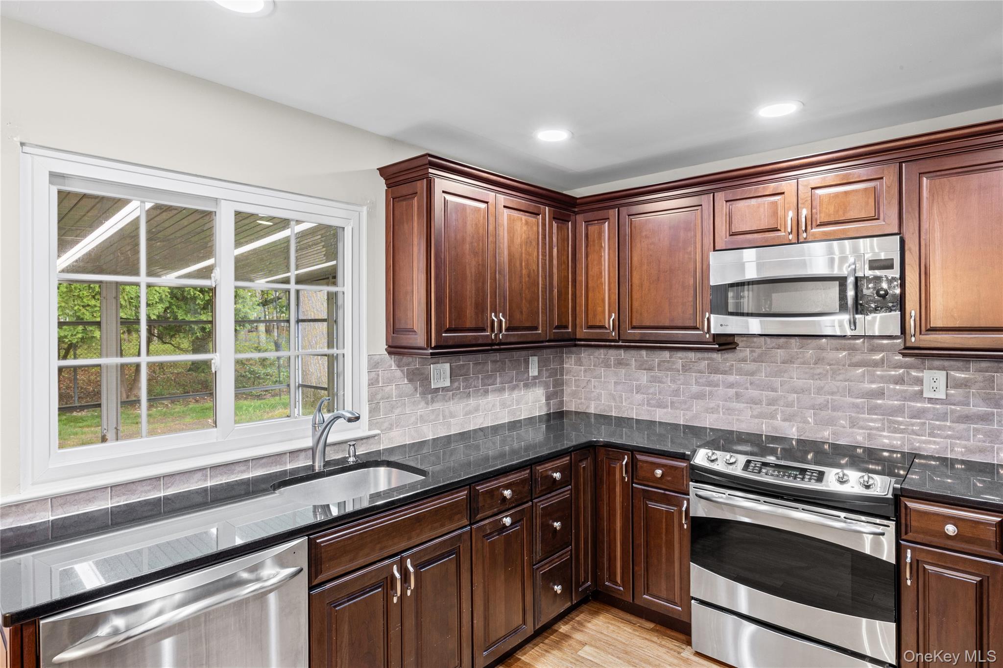 220 Belfast Lane Ridge, NY 11961 - Photo 22 of 44 a kitchen with a sink stove and microwave