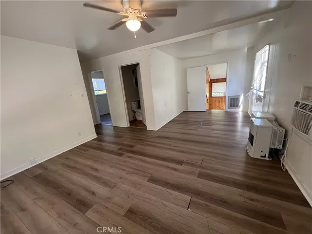 a view of a livingroom with wooden floor and an entryway