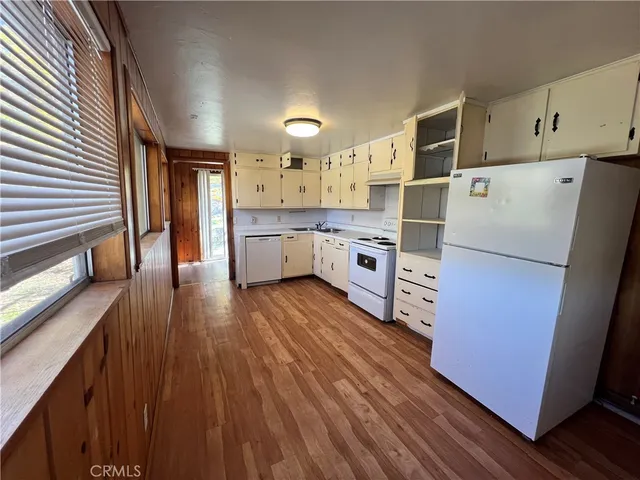 a kitchen with lot of cabinets and wooden floor