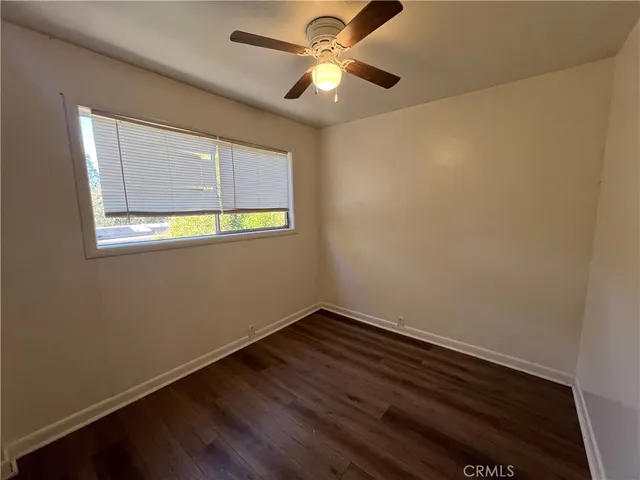 an empty room with a window and a ceiling fan