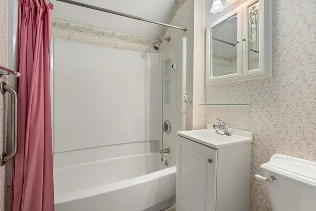 a white bath tub sitting next to a white sink and vanity