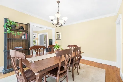a view of a dining room with furniture and chandelier