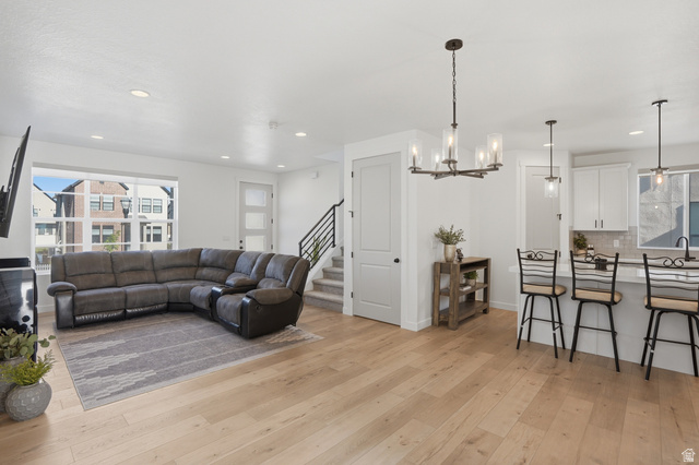 11531 Engelmann Drive Draper, UT 84020 - Photo 5 of 31 Bright open-concept living space featuring light wood-finish flooring, recessed lighting, and a modern chandelier