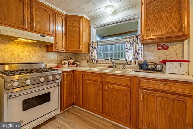 a kitchen with stainless steel appliances granite countertop a sink stove and cabinets