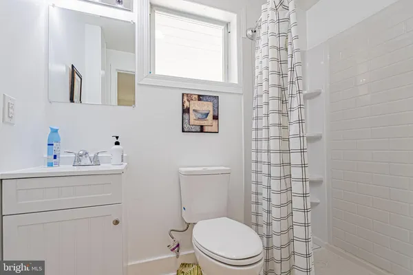 a bathroom with a toilet a sink a shower and a window