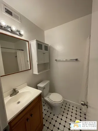 a bathroom with a sink a toilet a mirror and shower