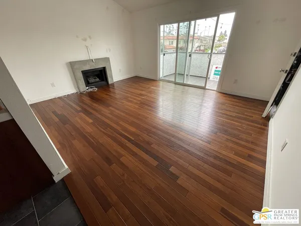 an empty room with wooden floor and fireplace