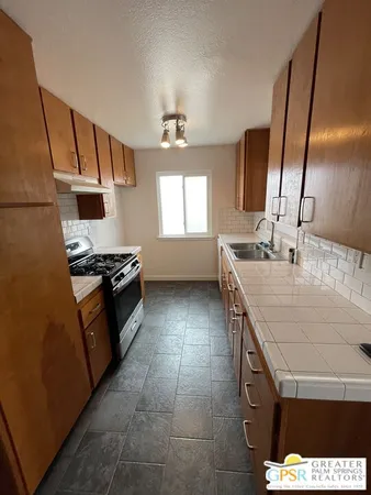 a kitchen with a sink a stove and a refrigerator