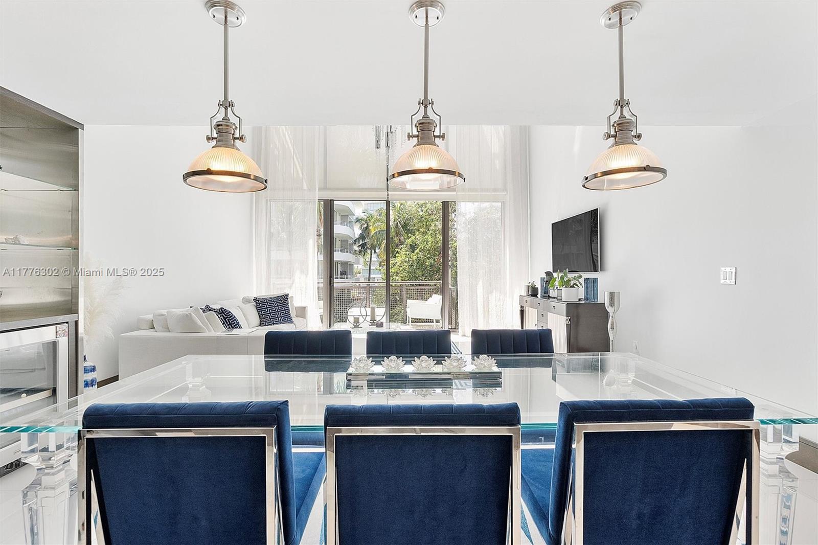 6000 Collins Avenue, Unit 326 Miami Beach, FL 33140 - Photo 16 of 45 a dining table with a chandelier and a living room view