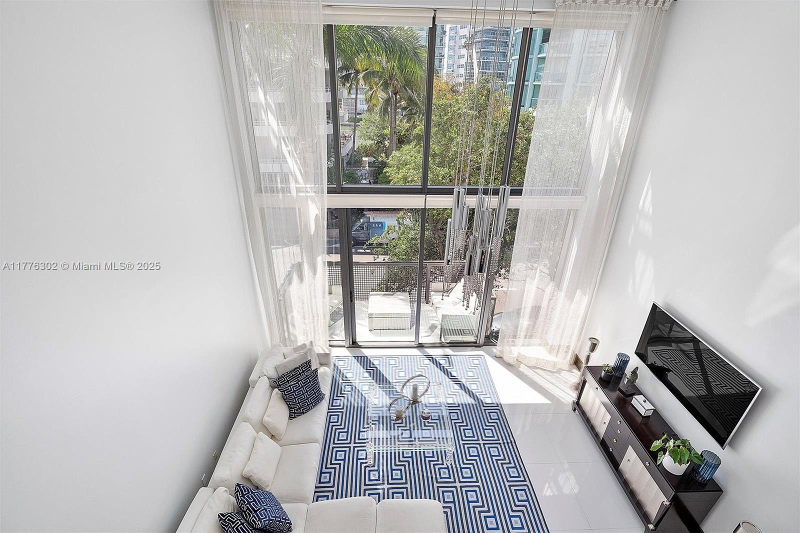 6000 Collins Avenue, Unit 326 Miami Beach, FL 33140 - Photo 20 of 45 a living room with furniture and a floor to ceiling window