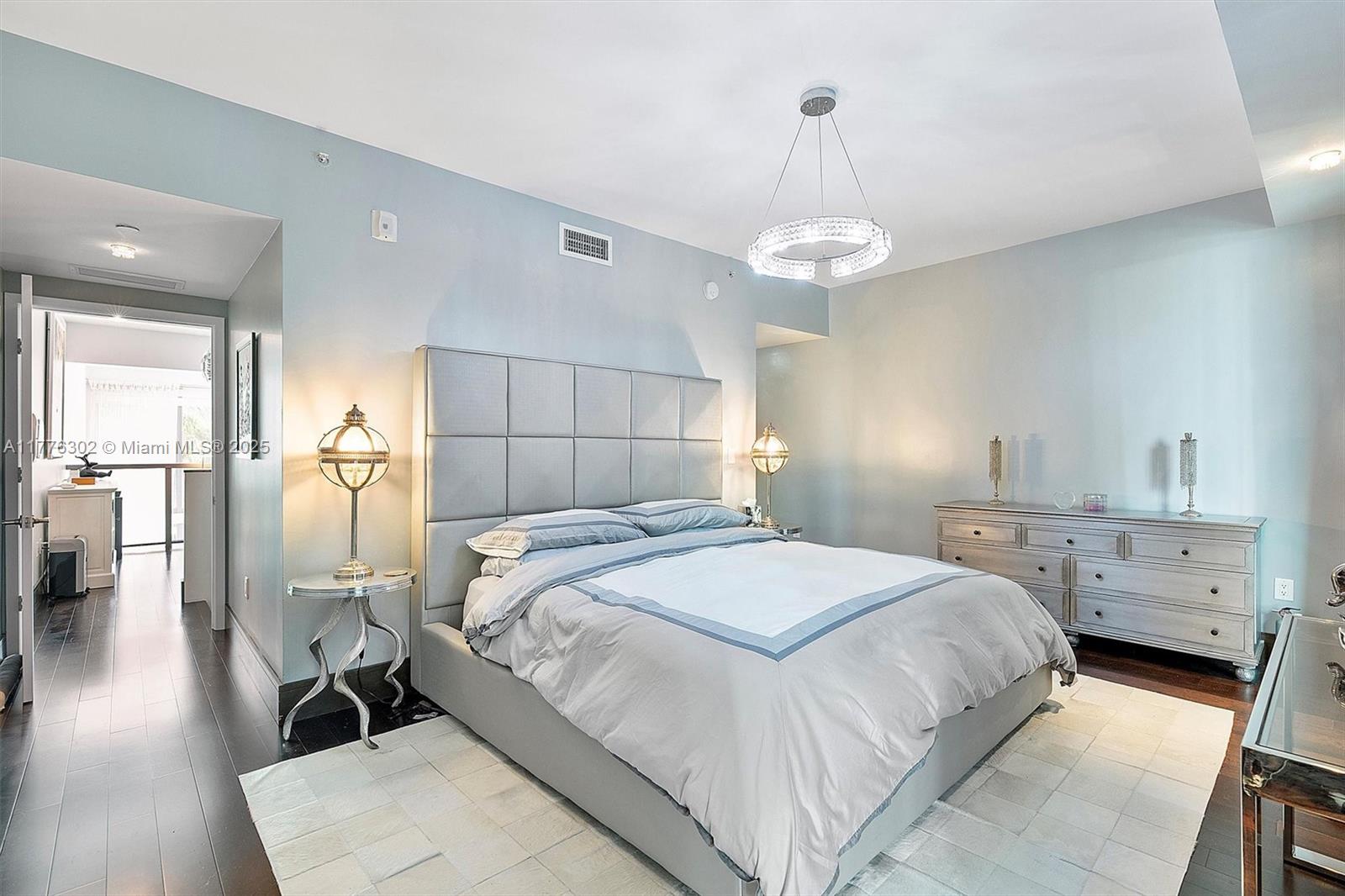 6000 Collins Avenue, Unit 326 Miami Beach, FL 33140 - Photo 25 of 45 a bedroom with a bed and a chandelier