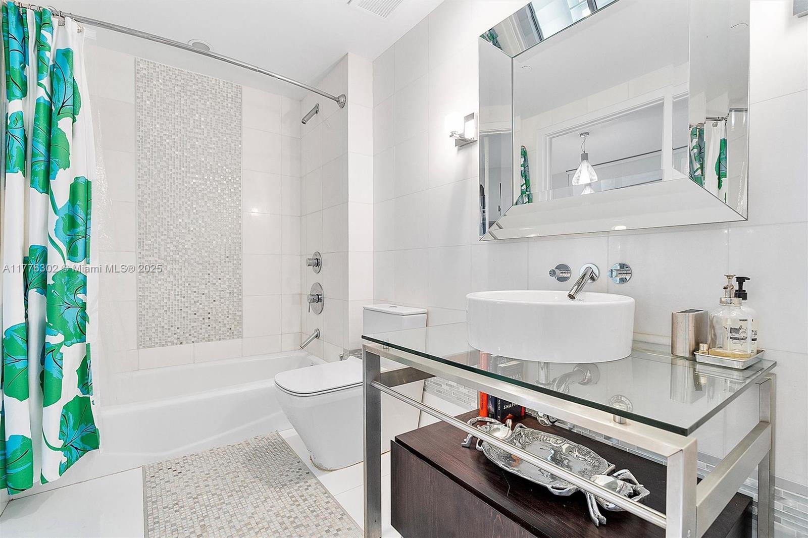 6000 Collins Avenue, Unit 326 Miami Beach, FL 33140 - Photo 36 of 45 a bathroom with a granite countertop sink a toilet a mirror and shower