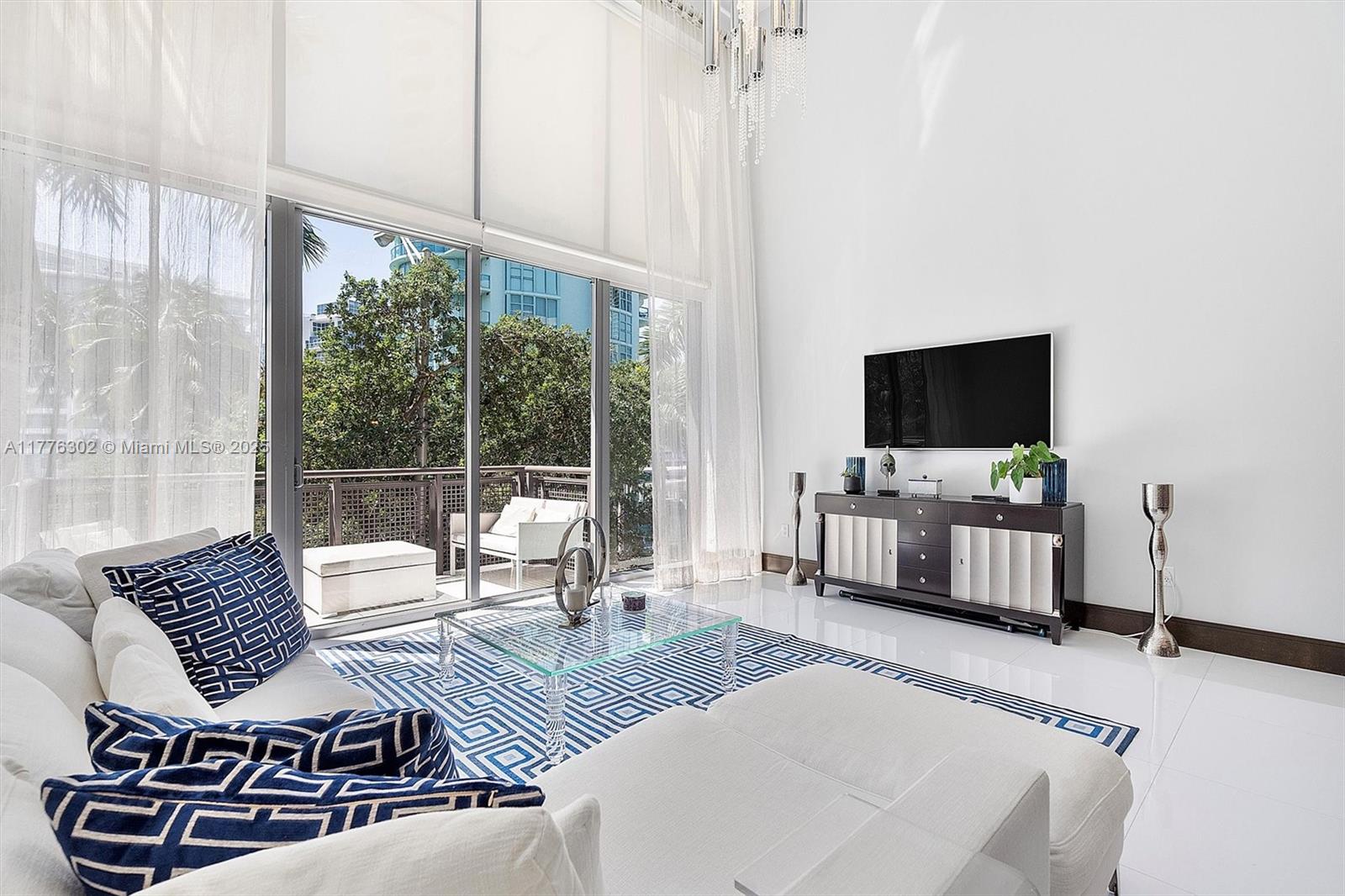 6000 Collins Avenue, Unit 326 Miami Beach, FL 33140 - Photo 8 of 45 a living room with furniture and a flat screen tv