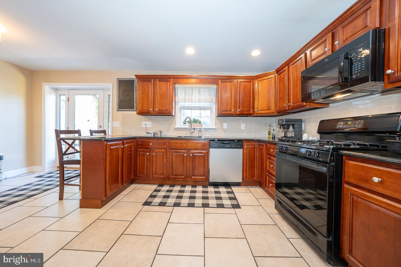226 East Springfield Road Springfield, PA 19064 - Photo 24 of 75 a kitchen with stainless steel appliances granite countertop a stove a sink dishwasher and a microwave oven with cabinets