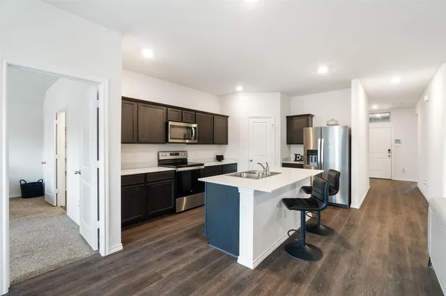 a kitchen with kitchen island a sink appliances and cabinets