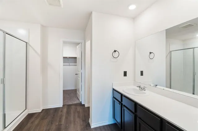 a bedroom with a bed and a flat tv screen on a dresser