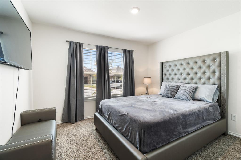 3413 Perman Drive Forney, TX 75126 - Photo 22 of 33 a bedroom with a large bed and a flat tv screen on dresser