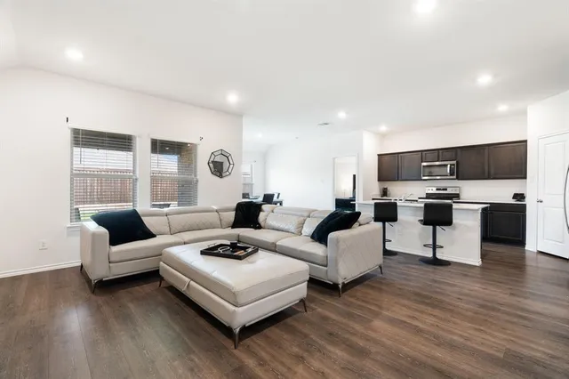 a living room with furniture a flat screen tv and a window