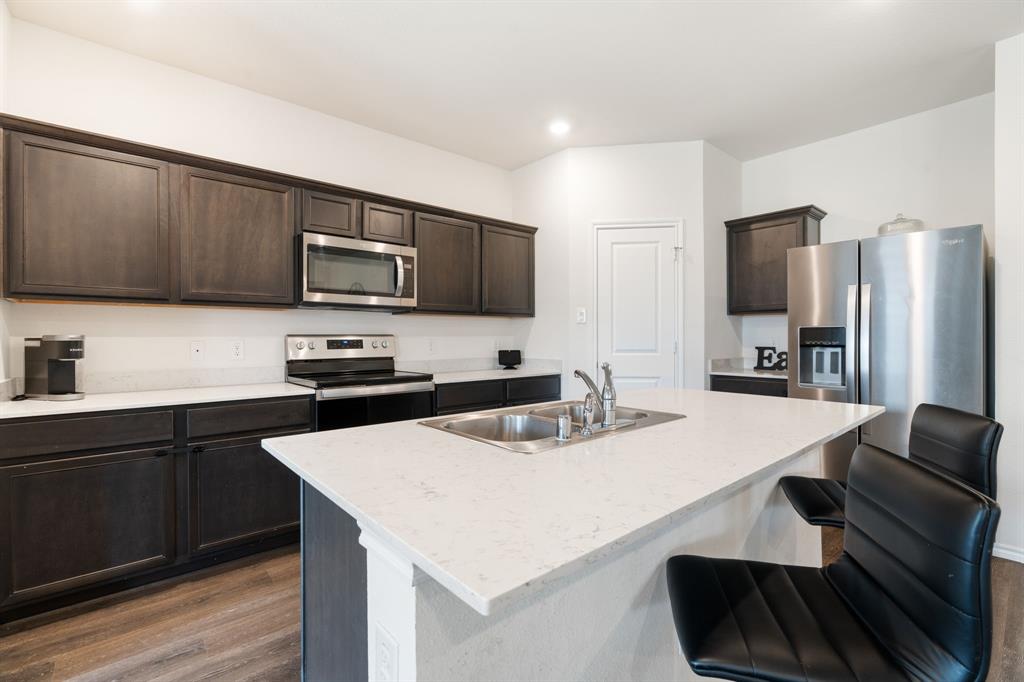 3413 Perman Drive Forney, TX 75126 - Photo 8 of 33 a kitchen with kitchen island a sink appliances and cabinets