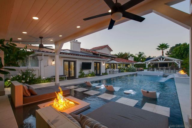a view of a house with swimming pool and sitting area