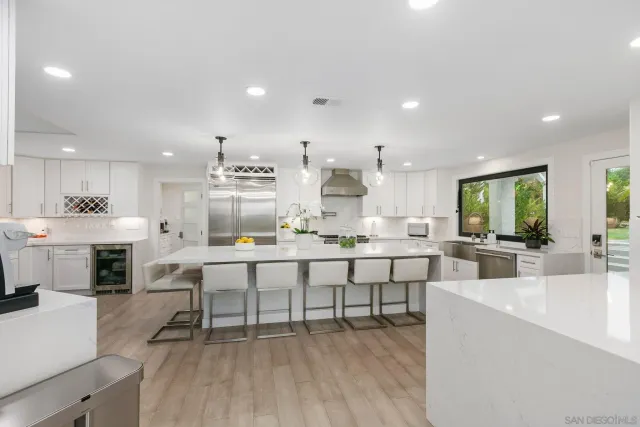 a spacious bedroom with a large bed a flat tv screen and a dresser