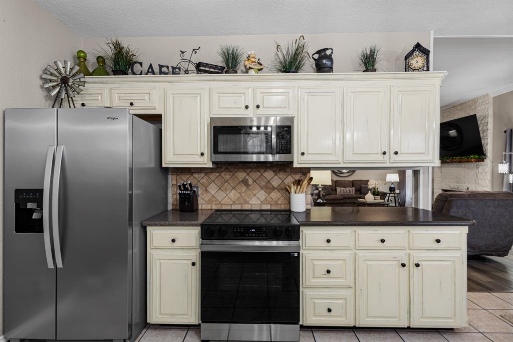 1701 Oakmeadow Drive Decatur, TX 76234 - Photo 8 of 39 a kitchen with stainless steel appliances white cabinets and a refrigerator