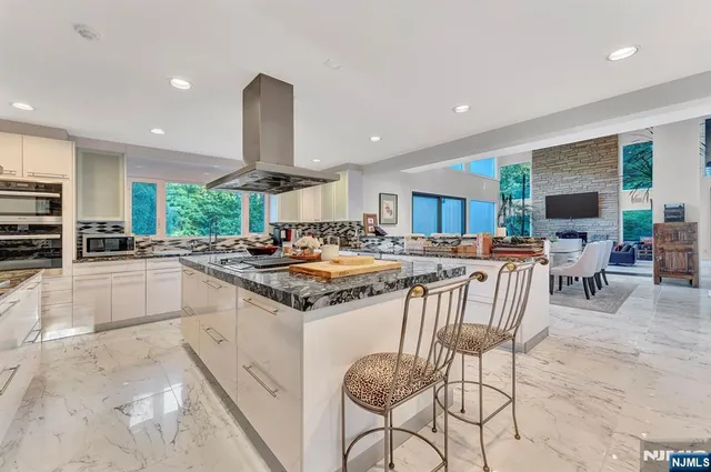 a large kitchen with stainless steel appliances granite countertop a large stove a sink and a white refrigerator