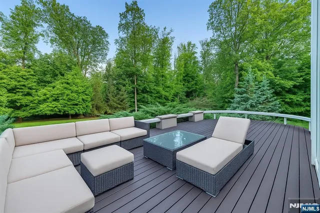 a view of a patio with couches table and chairs with wooden fence and plants