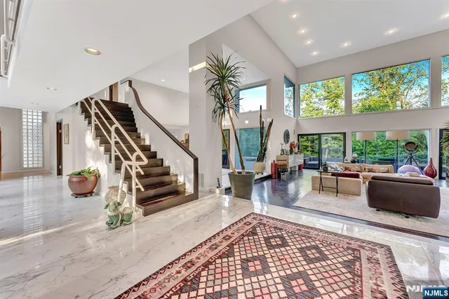 a living room with furniture large window and wooden floor