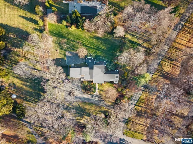 a view of a house with a big yard and large trees