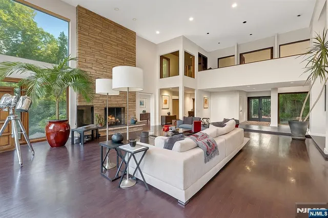 a living room with furniture a flat screen tv and a large window